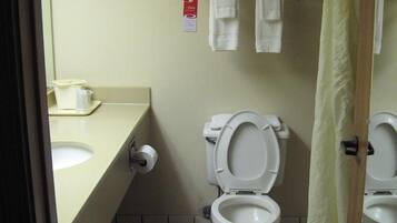 Un baño pequeño con inodoro, lavamanos y un perchero para toallas.