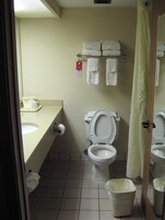 Un baño pequeño con inodoro, lavamanos y un perchero para toallas.
