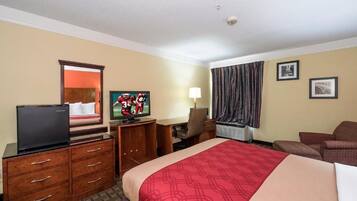 A hotel room with a bed, a desk, a television, a dresser, and a chair.