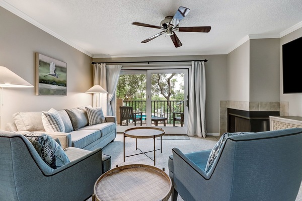 Beautifully Furnished Living Space with Two Chairs and a Sleeper Sofa Situated around a Large Flat Screen Smart TV (Fireplace not Functional)