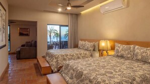 Une chambre d’hôtel avec deux lits, un ventilateur de plafond, la climatisation, un balcon avec vue et un coin repas.