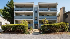 A two-story building with a central entrance, balconies on each floor, and a 'For Sale' sign. - Park and Walk! Downtown Rehoboth Beach Condo (Rehoboth Beach)