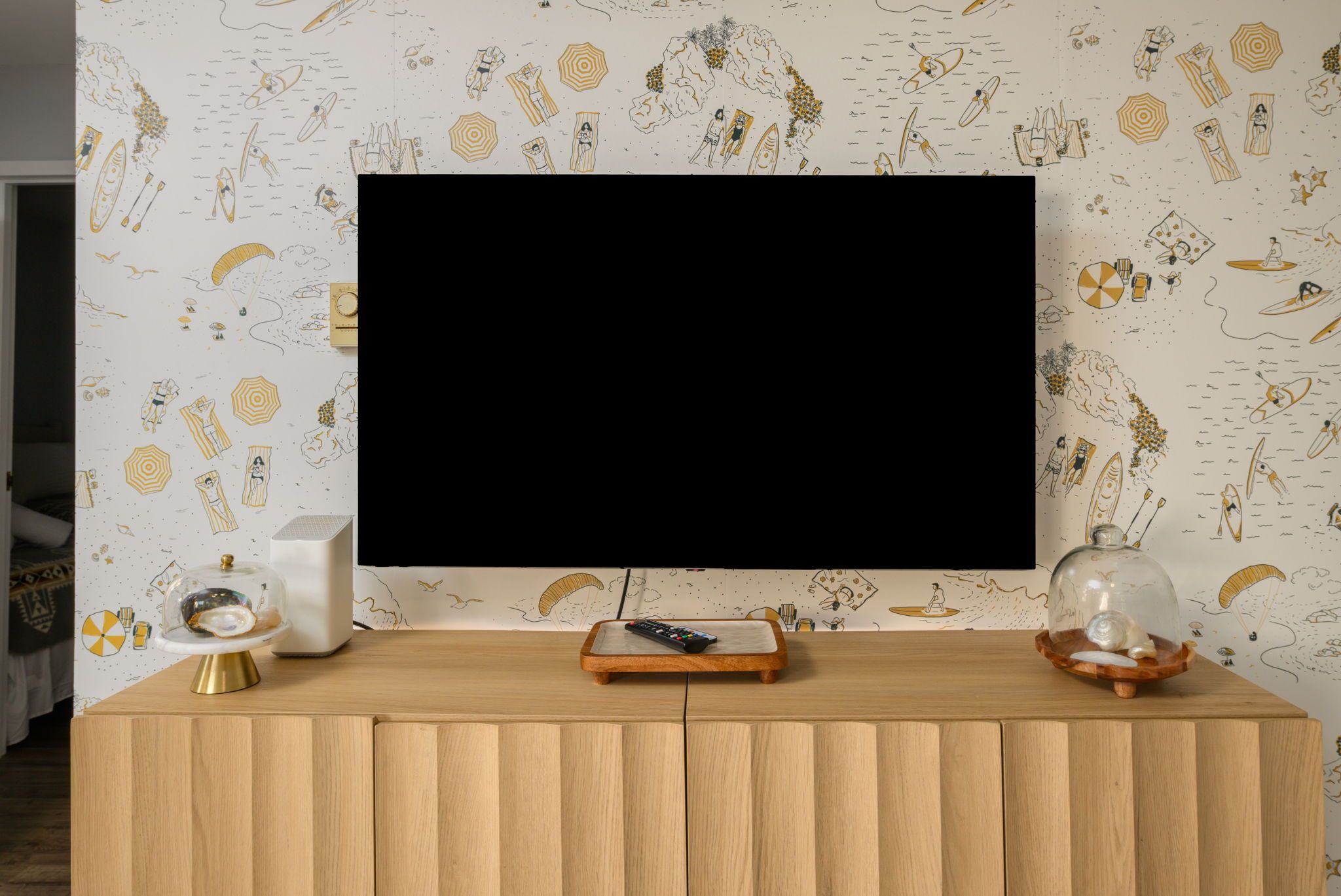 A modern living room with a large flat-screen TV mounted on a wooden cabinet.