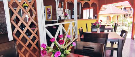 A reception area with a check-in counter, a reception desk, and a table with a vase of flowers.