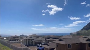 Zona residencial con varias casas, un estacionamiento cercado y vista al océano.