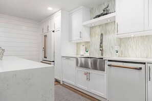 A modern kitchen with white cabinetry, a stainless steel sink, and a marble countertop. - Seaside Retreat - 3BR/3BA Gulf-Front Home - Private Pool & Beach Walkover - Sleeps 10 (Santa Rosa Beach)