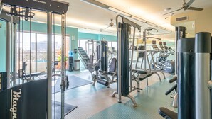 A gym with various exercise equipment, including a squat rack and weight machines. - A Touch of Class | MD Anderson/NRG (Houston)