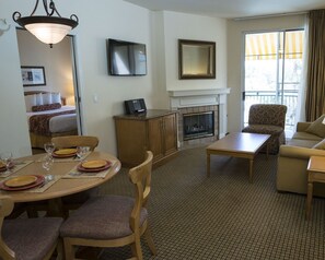 Relax in a cozy space with a comfortable seating area, dining table, and fireplace.