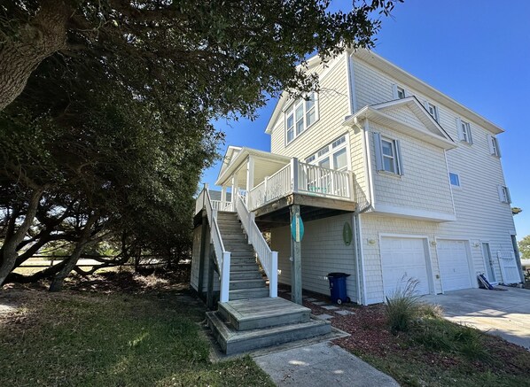 A two-story house with a front porch, a covered staircase, and a garage. - Holy Mackerel -Gorgeous, large home -Ocean view & Sound view -Great for families (Emerald Isle)