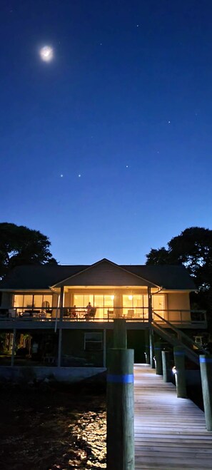 A two-story house with a wooden deck leading to a balcony. - Waterfront (Merritt Island)