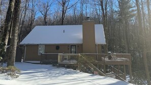 A two-story house with a snow-covered roof and a chimney, surrounded by trees. - Sky Valley Creekside Getaway! Hike-Swim-Golf! (Sky Valley)