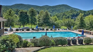 A swimming pool with lounge chairs and umbrellas, surrounded by lush greenery and hills. - Sky Valley Creekside Getaway! Hike-Swim-Golf! (Sky Valley)