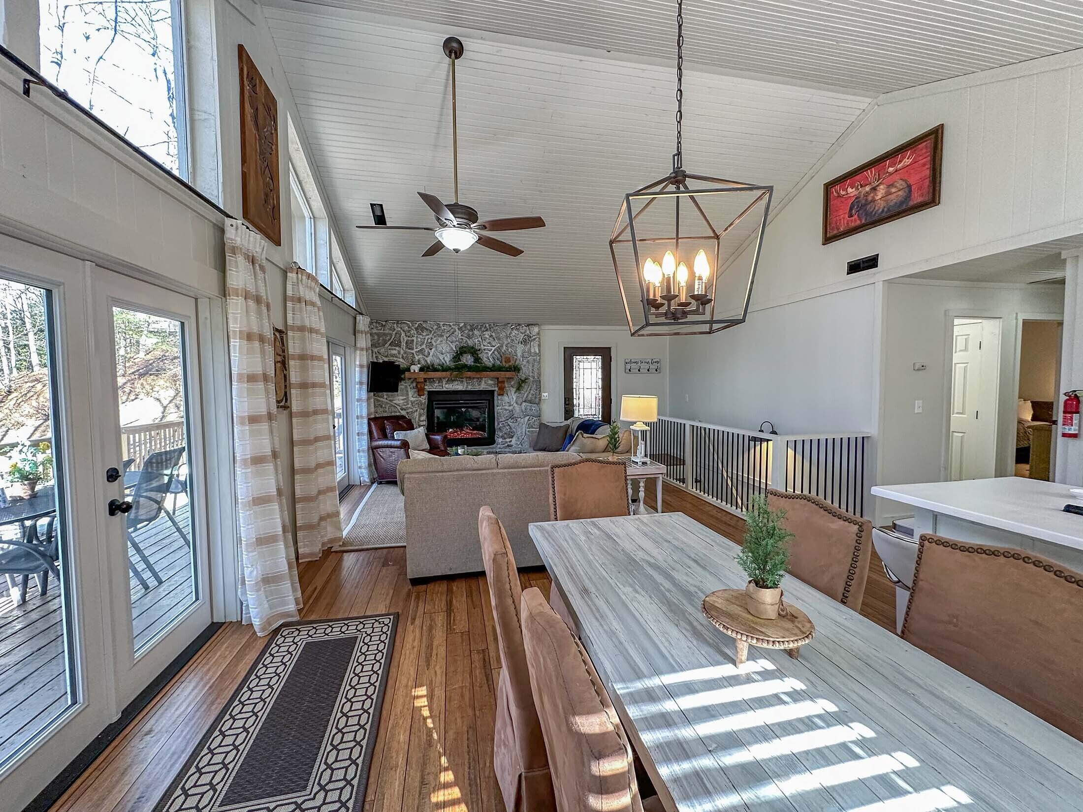 A spacious living area with a fireplace, wooden flooring, and a dining table with benches.