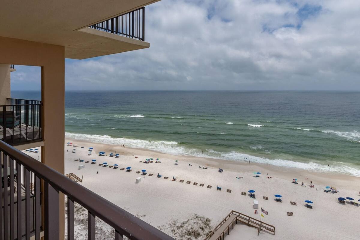 Un balcon avec vue sur une plage et l’océan.