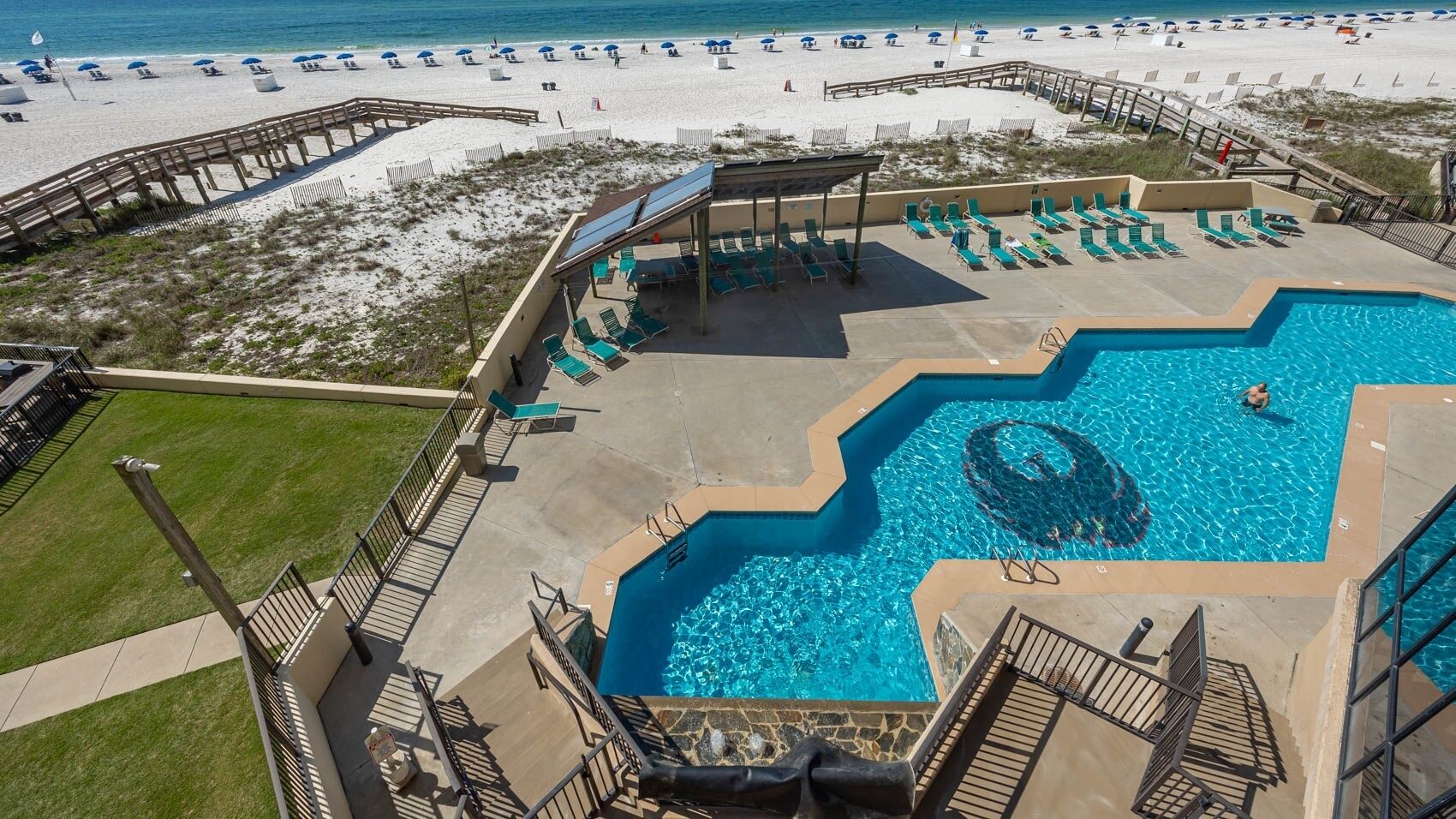 Ein Pool mit außergewöhnlichem Design, umgeben von Liegestühlen und einer Sonnenterrasse.