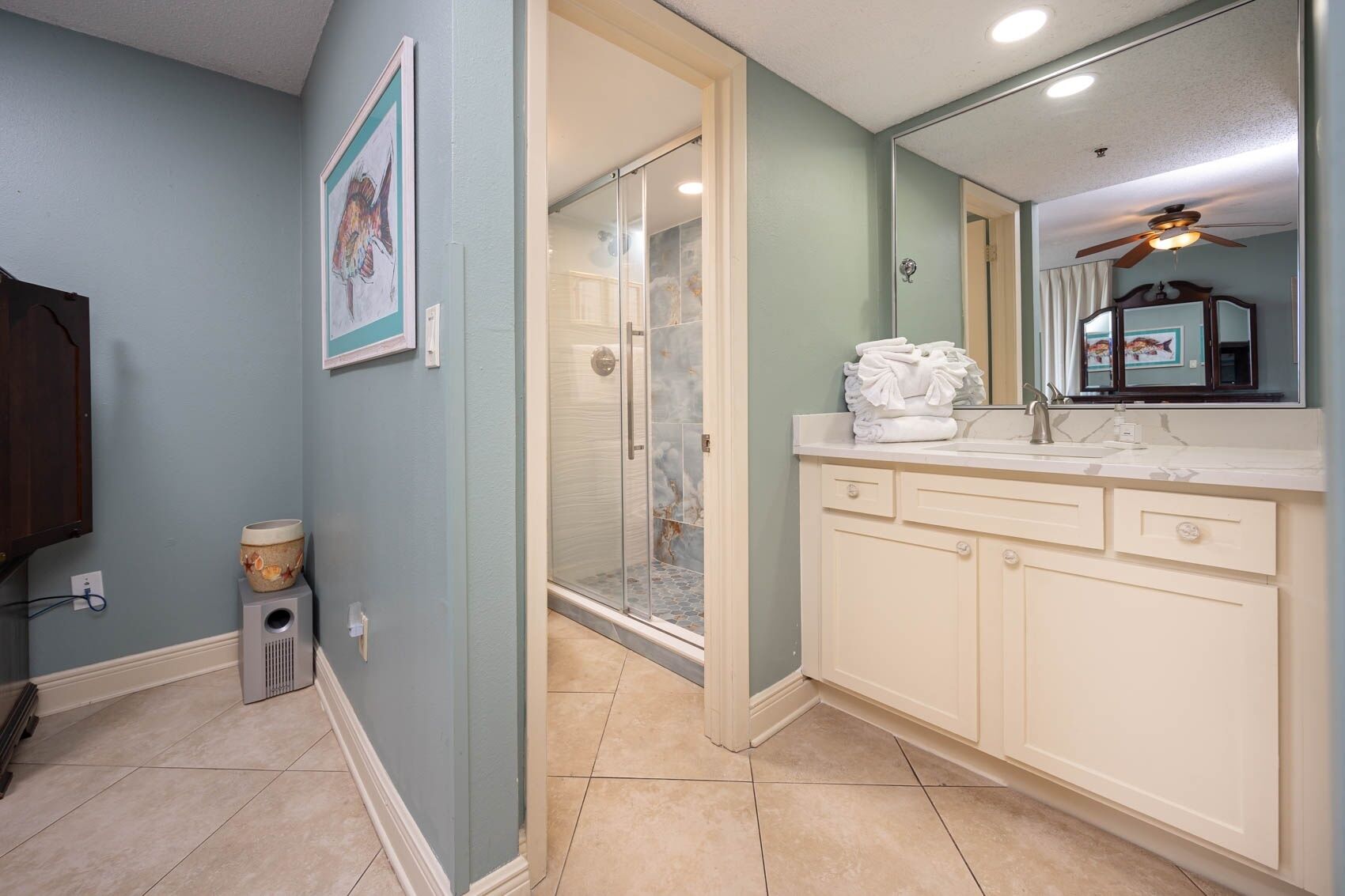 A bathroom with a shower, a sink, and a mirror.