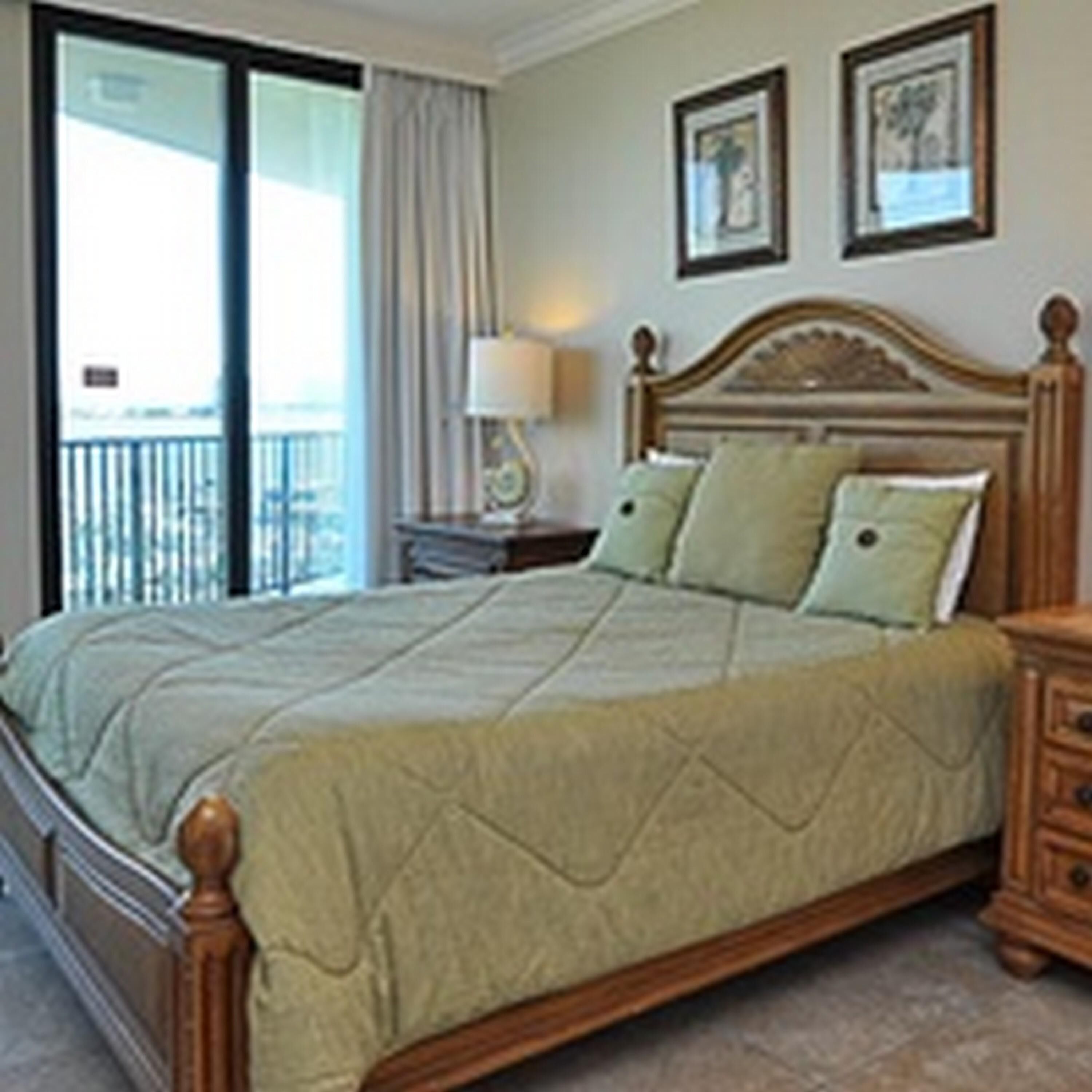 A bedroom with a bed, a nightstand, and a window with curtains.