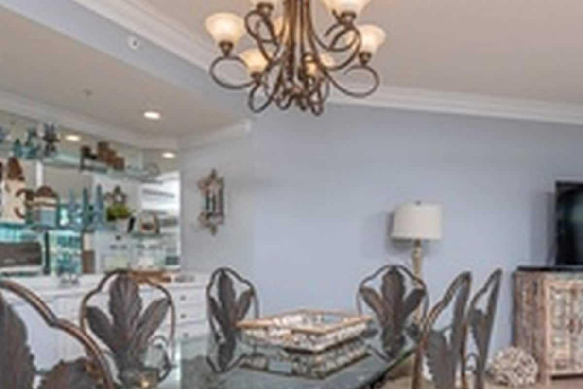 Un espace repas avec une table en verre entourée de chaises décorées.