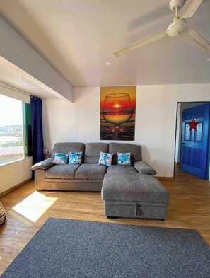 Relax in this stylish living room with a comfortable sofa, colorful throw pillows, and a beautiful painting above.