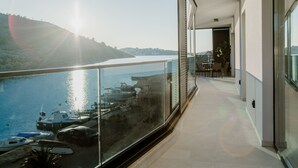 Varanda moderna com guarda-corpo de vidro e vista para uma marina com barcos.