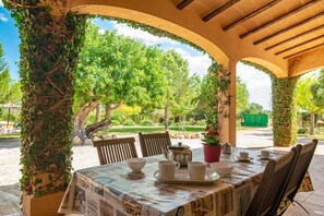 An outdoor patio with a table set for tea, surrounded by wooden chairs and covered by a newspaper tablecloth. - LOS GIRASOLES - Wonderful villa with private pool and only 10 km away from the paradisaica (Campos)