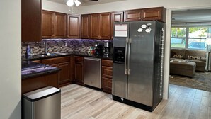Una cocina moderna con armarios de madera, un refrigerador de acero inoxidable y un horno empotrado.