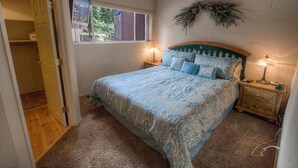 A bedroom with a bed, two bedside tables, a window, and a door. - Heavenly Mountain Hideaway 2 Bedroom Home by RedAwning (South Lake Tahoe)