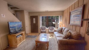 A living room with a television, a wooden cabinet, a sofa, and a coffee table. - Heavenly Mountain Hideaway 2 Bedroom Home by RedAwning (South Lake Tahoe)
