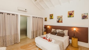 Un dormitorio con cama, cortinas, mesita de noche y decoración en la pared.