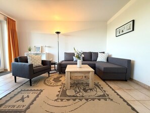 A modern living room with two sofas, a coffee table, and a floor lamp.