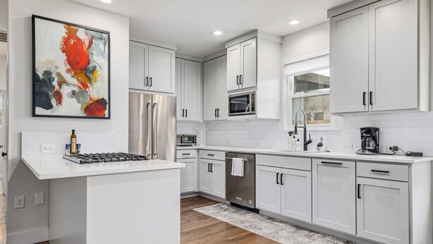 Una cocina moderna con armarios blancos, electrodomésticos de acero inoxidable y una isla grande.