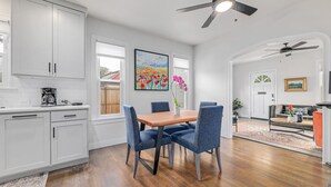 Una cocina moderna con armarios blancos, una mesa de comedor de madera y sillas azules.