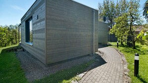 Un bâtiment moderne doté d’un toit plat, d’une grande fenêtre et d’un trottoir dallé.