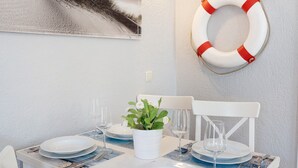 Una mesa de comedor dispuesta con platos, vasos y una planta en maceta.