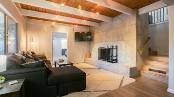 TV connectée, cheminée, table de tennis de table, livres