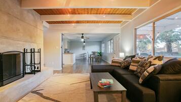 TV connectée, cheminée, table de tennis de table, livres