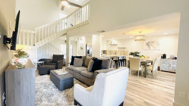 A spacious living area with a staircase, a dining area, and a kitchen.