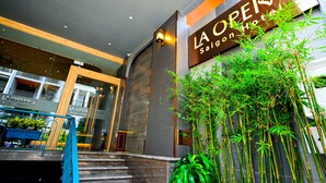 The entrance of La Opera Saigon Hotel with a modern design, featuring a staircase and a large sign. - LA OPERA SAIGON HOTEL (Ho Chi Minh City)