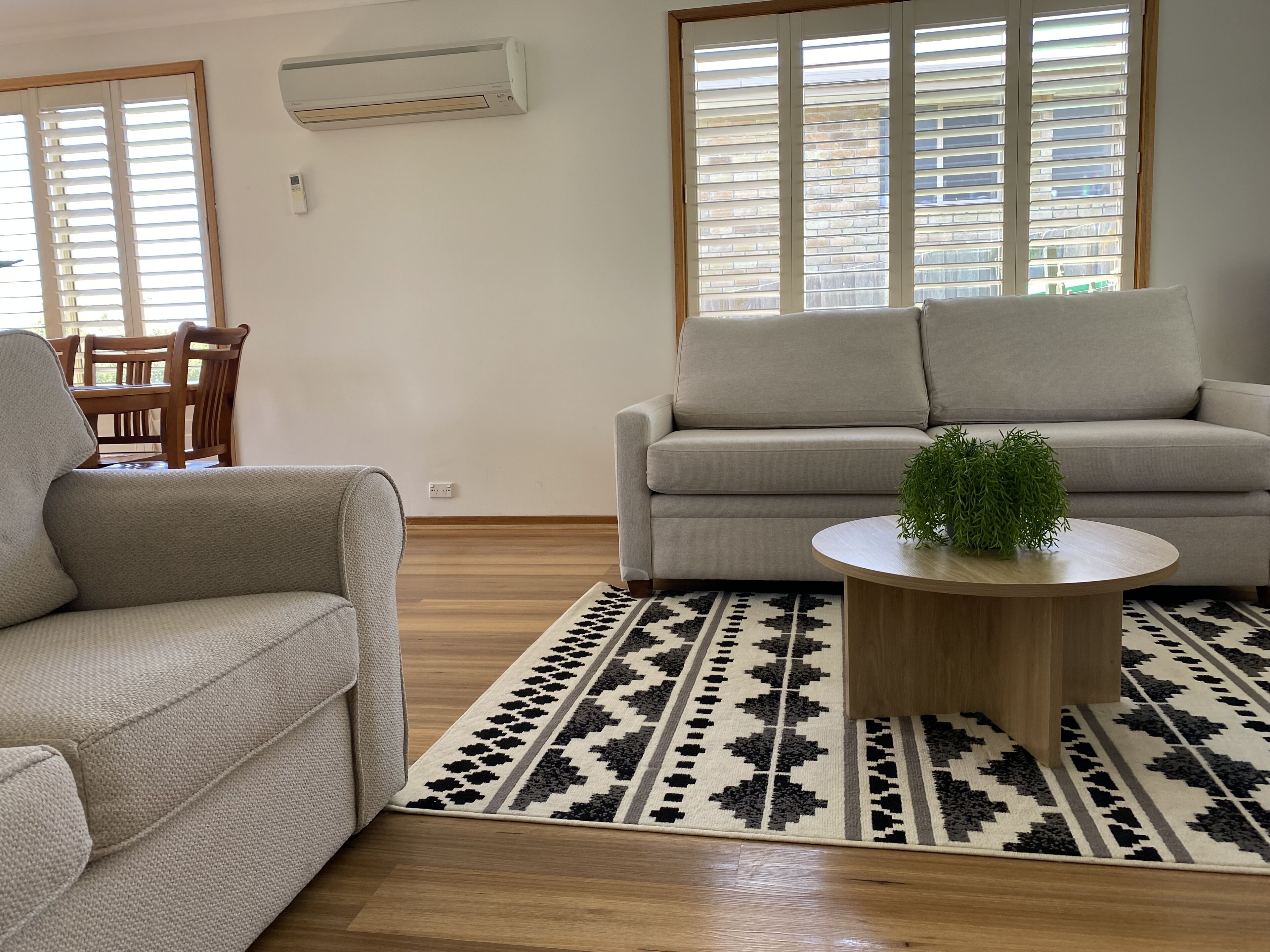 A living room with two sofas, a coffee table, and a patterned rug.