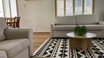 A living room with two sofas, a coffee table, and a patterned rug.