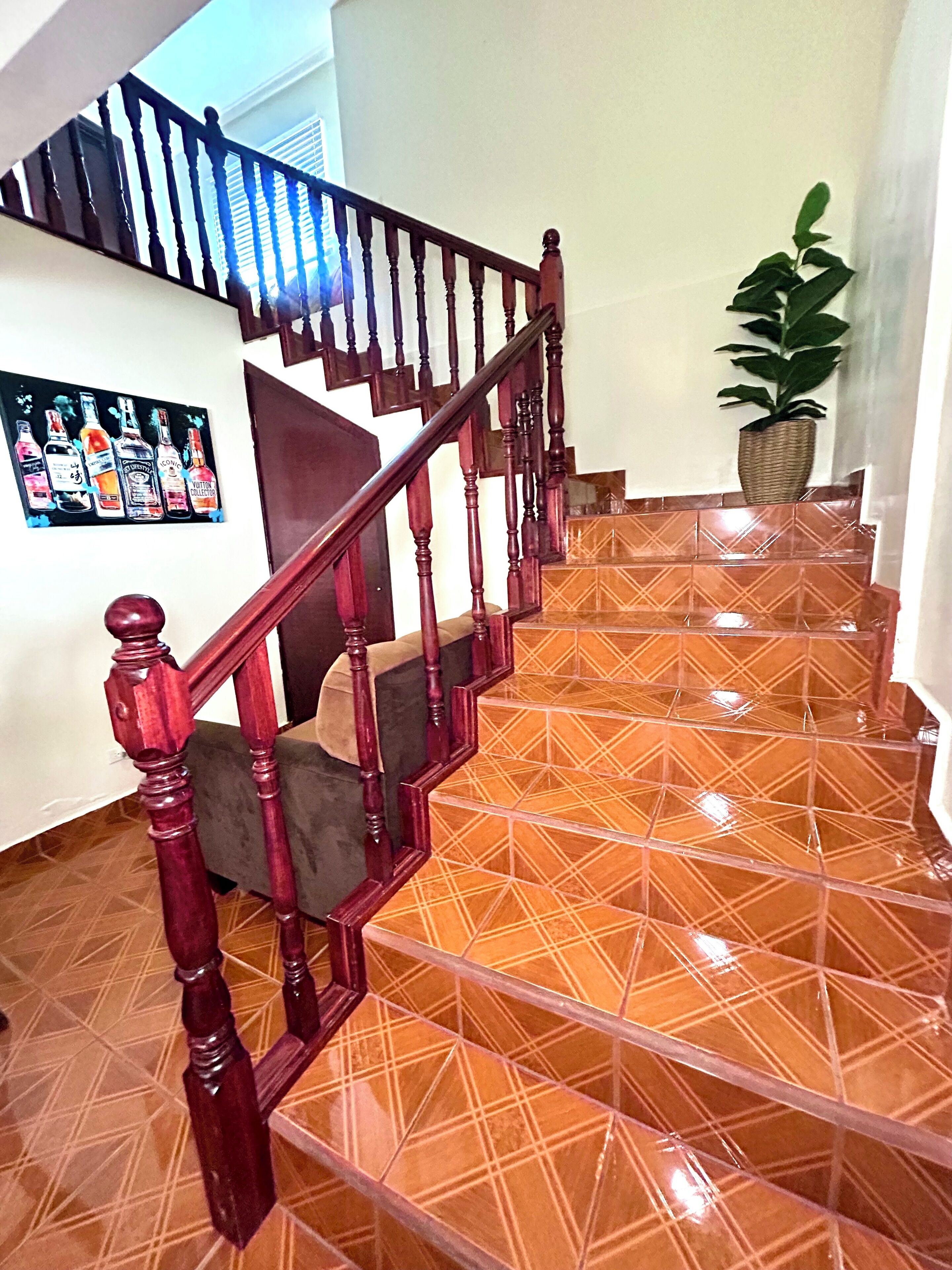 A staircase with wooden balusters and a tiled floor.