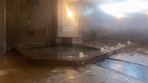A steam room with stone walls, a glass partition, and a metal railing. - Tabist Hotel Chouseikaku (Yatsushiro)