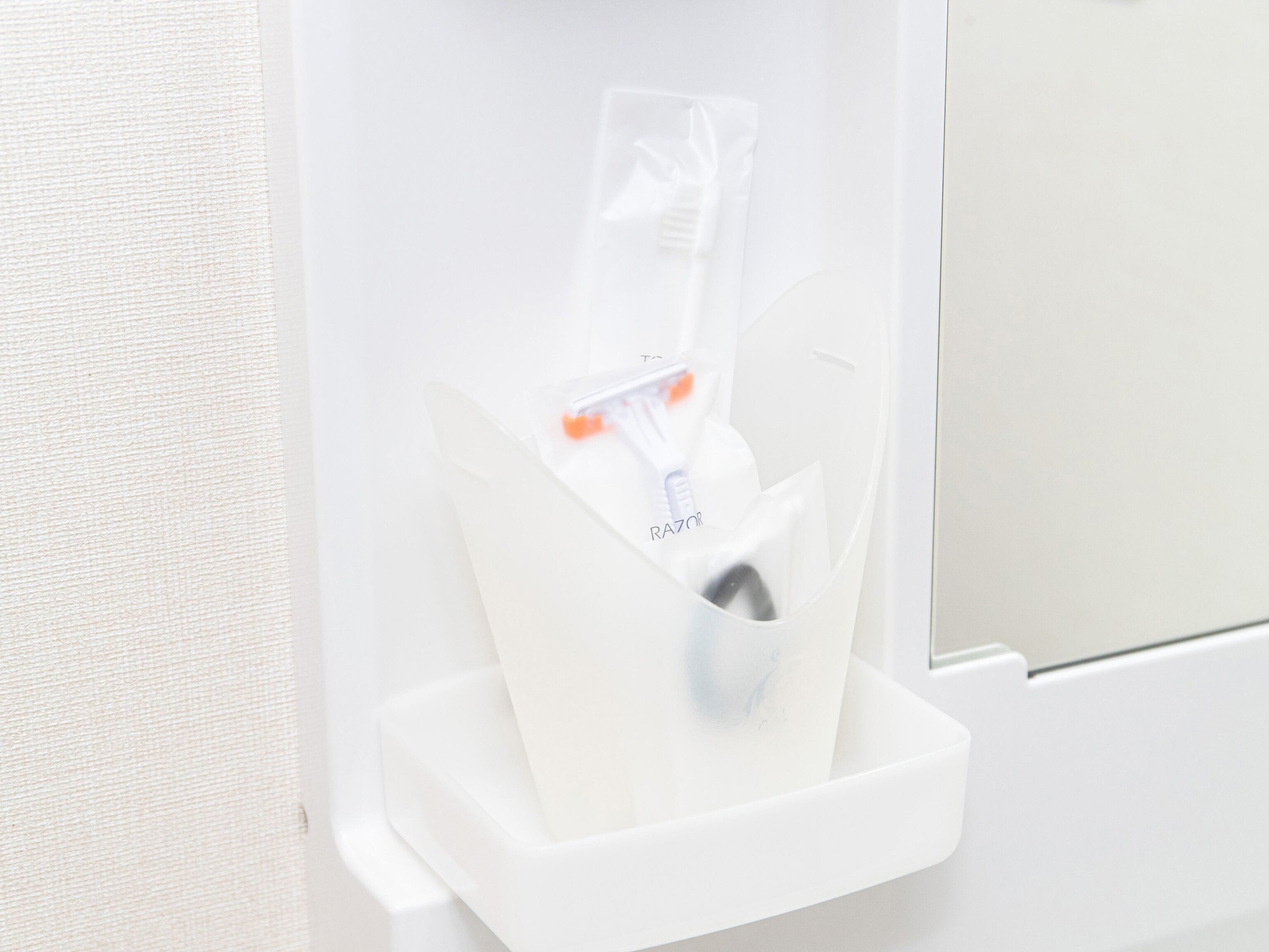 A bathroom with a white sink and a razor holder.