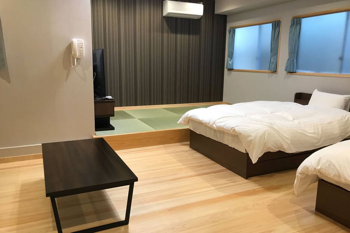 Een hotelkamer met een bed, nachtkastje en een zithoekje.