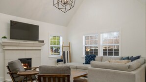 Ein Wohnzimmer mit Kamin, Fernseher und einer Couch.