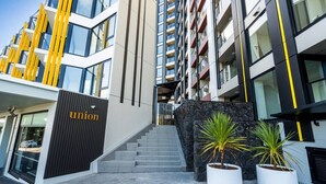 Un edificio moderno con una escalera que conduce a una entrada, un letrero con la palabra 'union' y dos plantas en macetas.