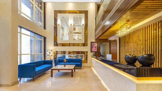 Un'ampia hall con un divano blu, un tavolino da caffè e una reception.
