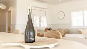 Un salon moderne avec une table ronde en bois, une bouteille de vin et deux verres.