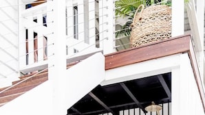 Un bâtiment blanc avec un escalier en bois menant à un balcon.