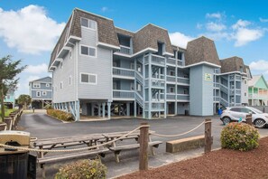 A multi-story hotel with a light blue exterior and a balcony on each floor.